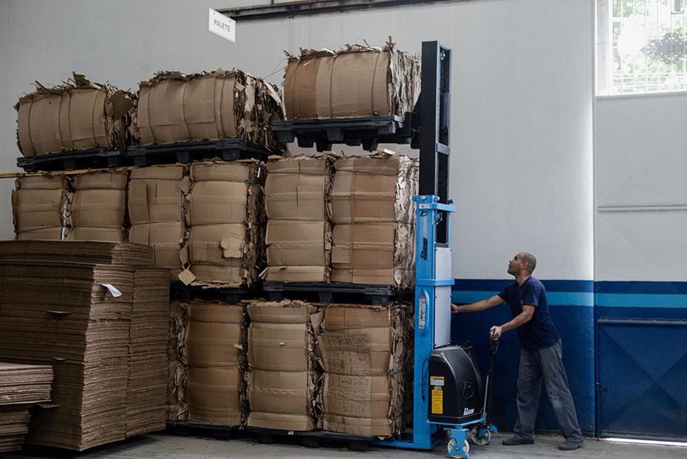 Fardos de aparas de papelão empilhados sobre uma empilhadeira